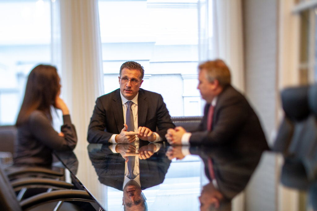 Three people sitting around a conference table having a discussion